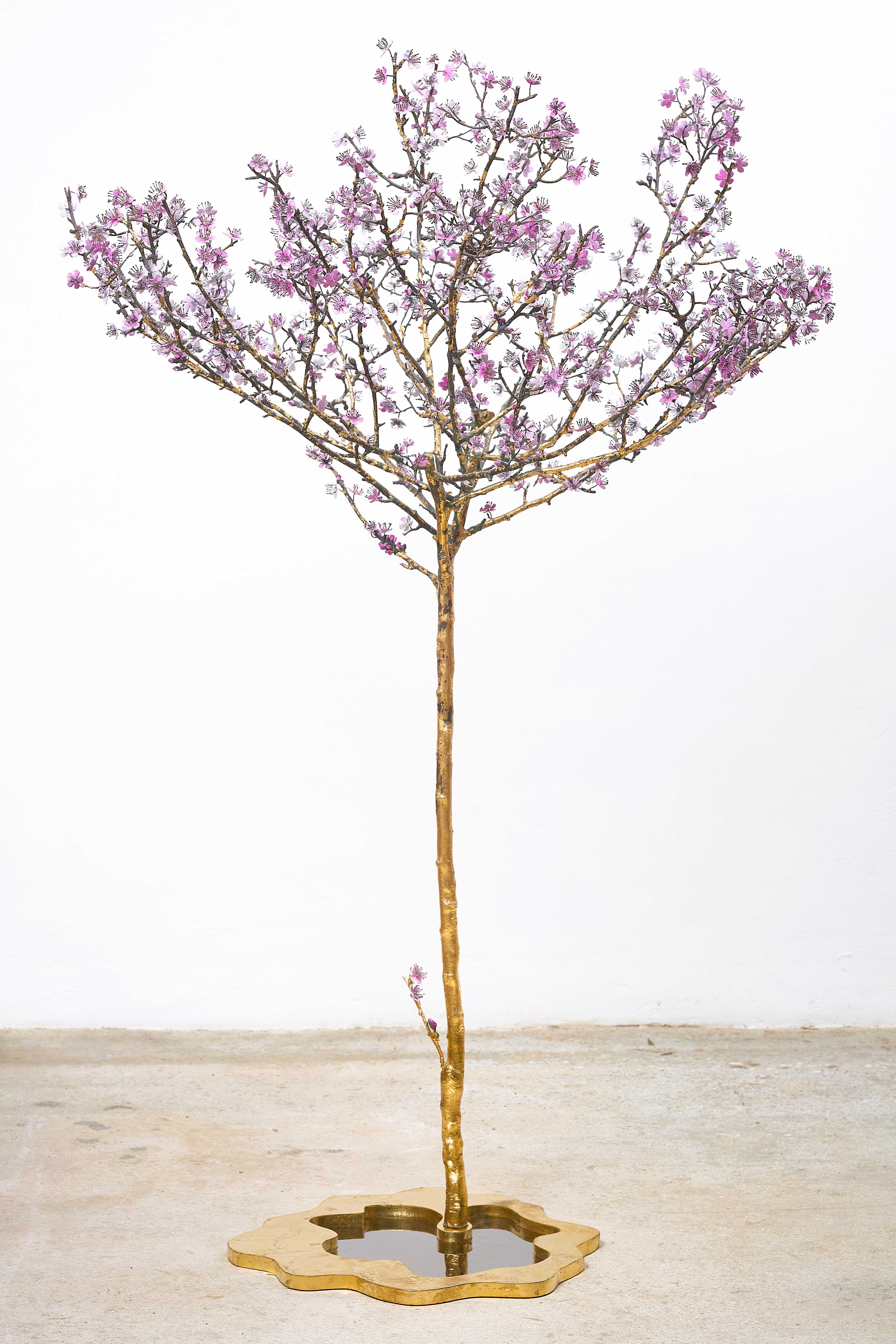 An elegant sculpture of a tall, slender tree with branches that reach uppwards, adorned with pink blossoms capturing the ephermal beauty of spring, grounded by a shadow-casting base that mimics the gentle ripples of water, symbolizing the beauty of nature's resilience.